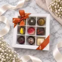 Doosje met 9 pralines in een kartonnen doosje met een plexiglas cover.